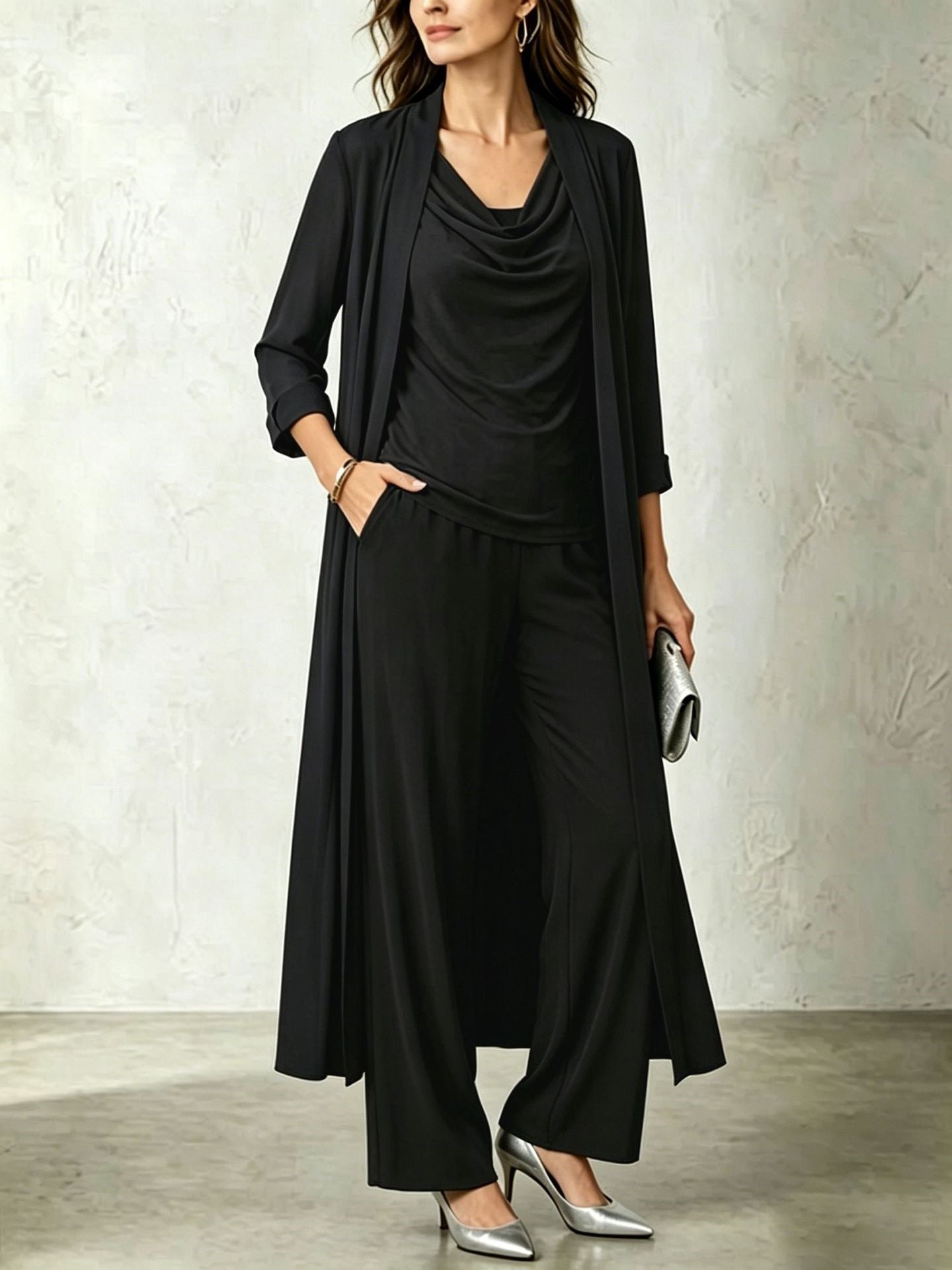 Classic black three-piece women's set featuring a long open duster cardigan, cowl neck top, and fluid wide-leg pants