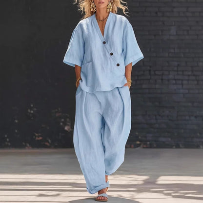 Model wearing a light blue V-neck short-sleeve top and matching high-waist trousers set.