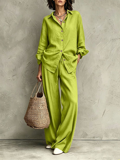 Women's button-down shirt and wide-leg pants set in black – full outfit front view showing relaxed casual silhouette and straw bag