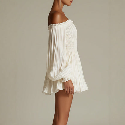 Side profile of a woman wearing a cream white off-shoulder pleated mini dress with long puff sleeves