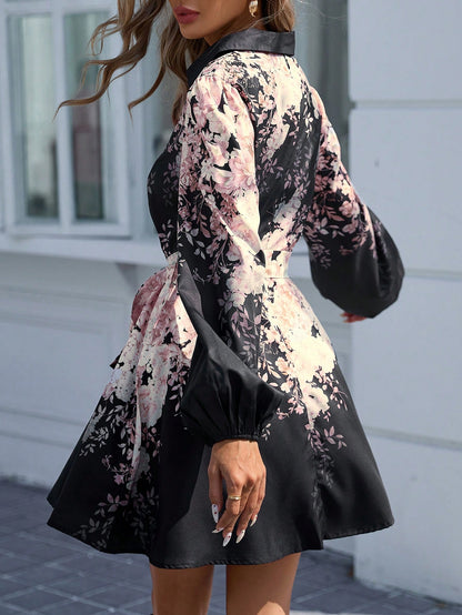 Rear view of a woman walking away outdoors, wearing a black mini shirt dress with a pink floral print, long lantern sleeves, and a fitted waist.