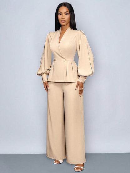 Front full-length view of a woman posing in an apricot beige suit set featuring a wrap V-neck blazer with puffed slit long sleeves and cinch waist, paired with matching wide-leg trousers.