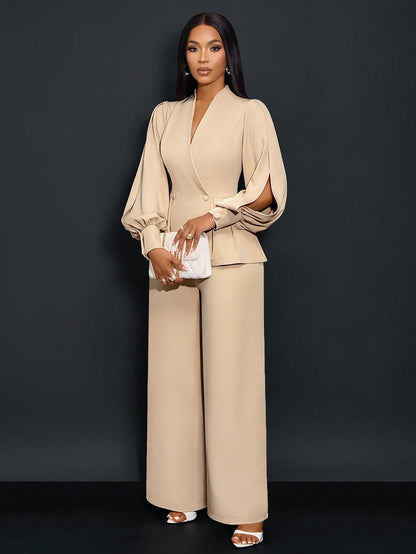 Front full-length view of a woman posing in an apricot beige textured suit set featuring a V-neck peplum blazer with puffed slit long sleeves, paired with wide-leg trousers and holding a white clutch bag.