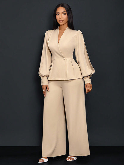 Front full-length view of a woman posing in an apricot beige suit set featuring a V-neck wrap blazer with long bishop sleeves and matching wide-leg pants.
