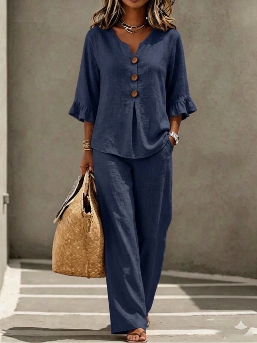 Women's two-piece set in navy blue, featuring a button-down V-neck ruffle top, matching relaxed-fit pants, and three-quarter sleeves.
