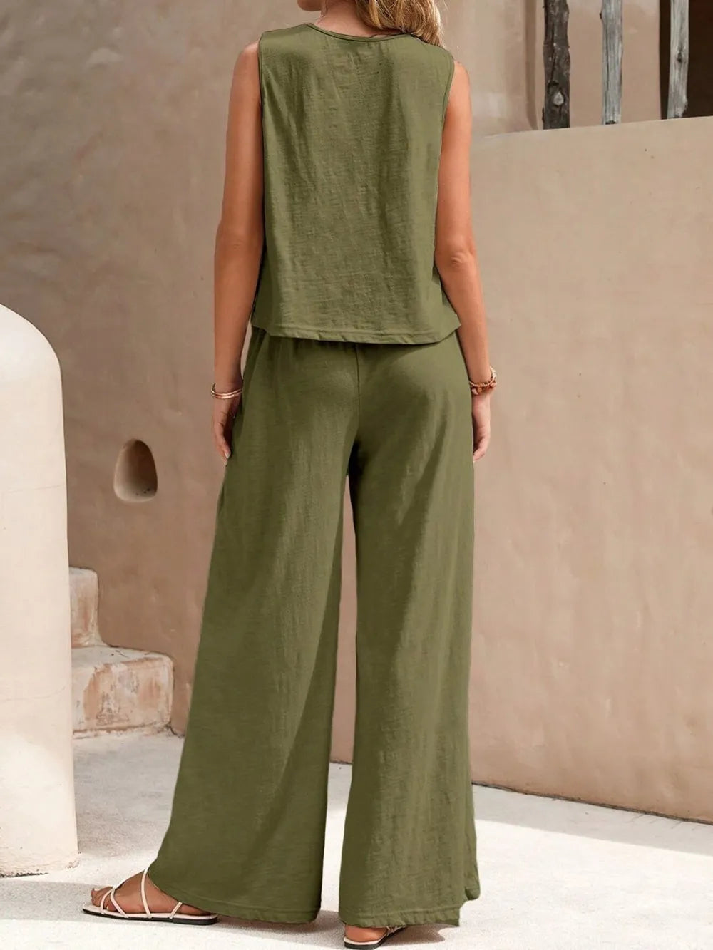 Back view of model wearing an army green sleeveless round neck top and high-waisted wide leg pants set with sandals