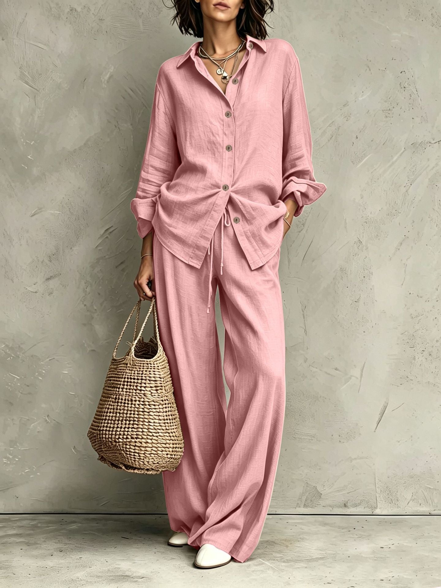 Women's button-down shirt and wide-leg pants set in pink – full outfit front view showing relaxed casual silhouette and straw bag