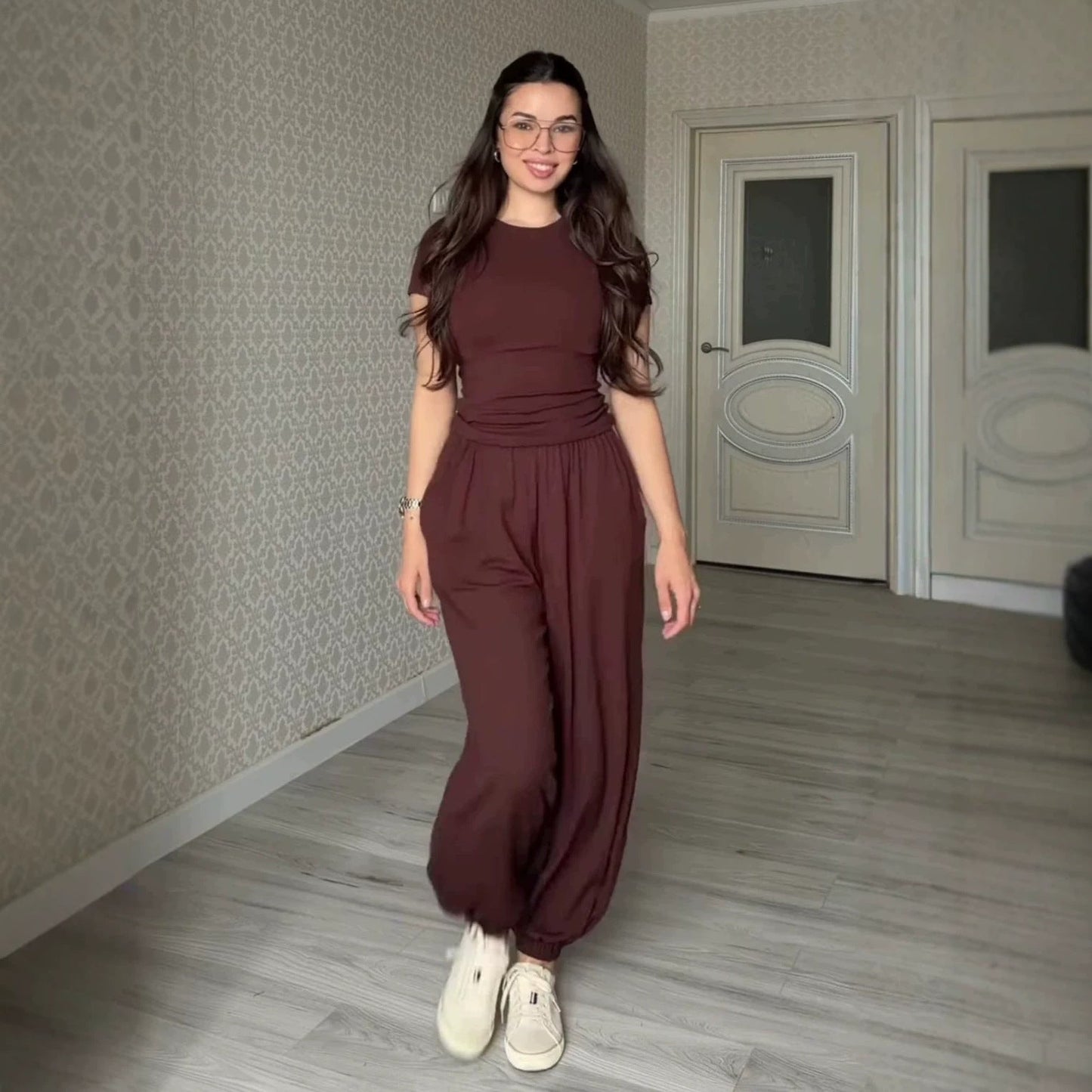 Women's chocolate brown two-piece set featuring a fitted short-sleeve crew neck tee and matching high-waisted, flowy wide-leg harem pants with cinched ankles.