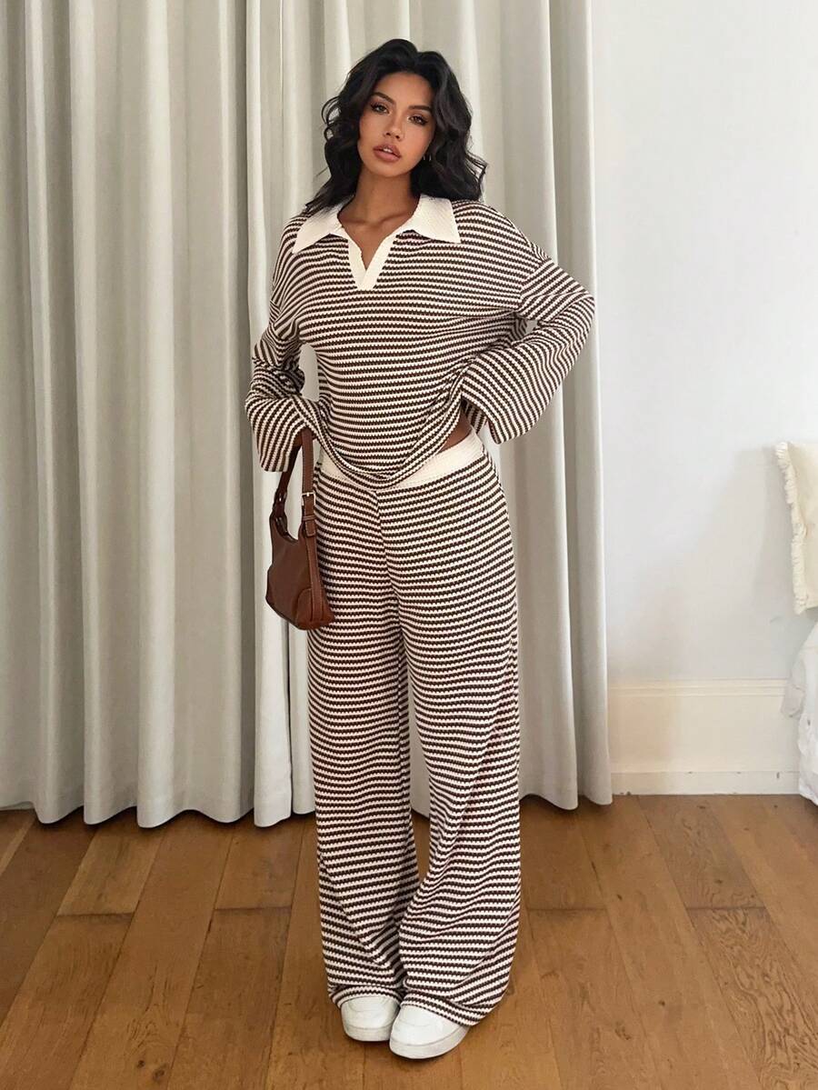 Full-body outdoor shot of a woman wearing a light blue off-the-shoulder floral midi dress with a contoured silhouette, asymmetric trumpet hem, white high heels, and a beige tote bag.