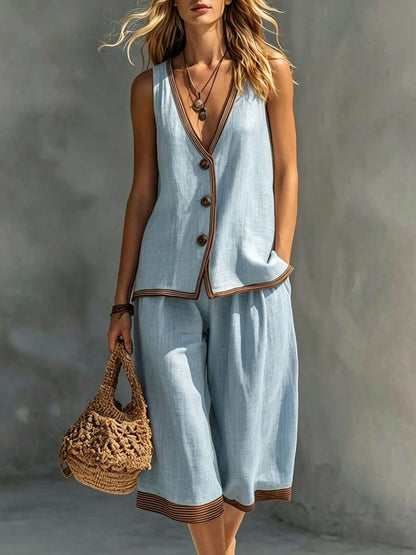 Women's light blue sleeveless buttoned vest and matching cropped wide-leg pants two-piece set featuring contrast trim detailing, modeled outdoors with a woven handbag