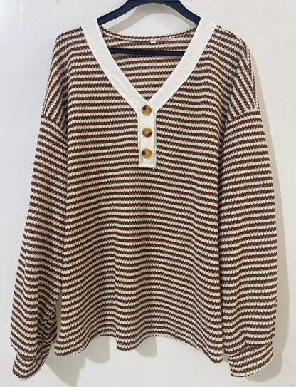 Brown and white fine-striped knit long-sleeve top featuring a three-button front placket with tortoise-shell buttons and a contrasting white V-neck collar, displayed on a black hanger.