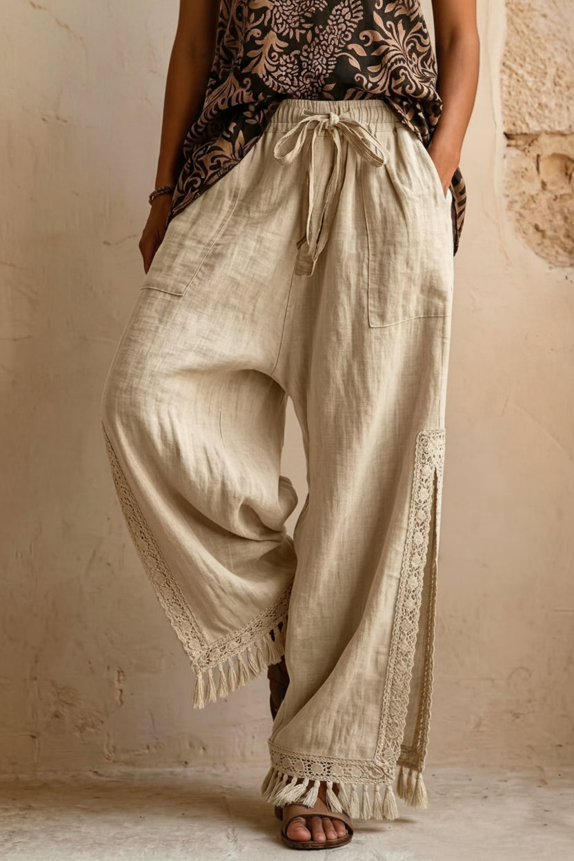 Women's bohemian lace tassel wide-leg pants in black, featuring a drawstring waist, side slit with fringe trim, and a flowing silhouette.