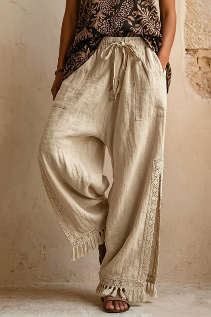 Women's bohemian lace tassel wide-leg pants in black, featuring a drawstring waist, side slit with fringe trim, and a flowing silhouette.