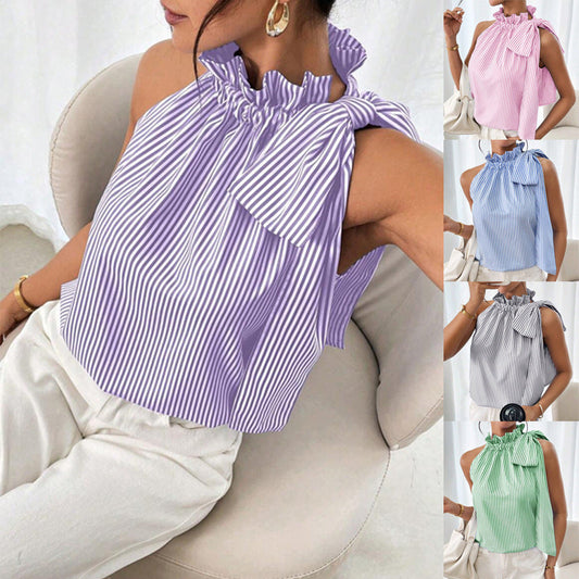 Front view of a model sitting down wearing a purple and white striped sleeveless top featuring a ruffled high neck and tie-knot bow detail.