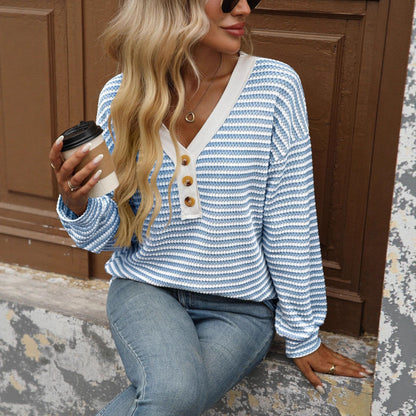 Woman wearing a sky blue and white striped V-neck long-sleeve top with button placket