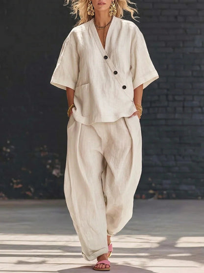 Model wearing a beige button-accent V-neck short-sleeve top and matching high-waist trousers set.