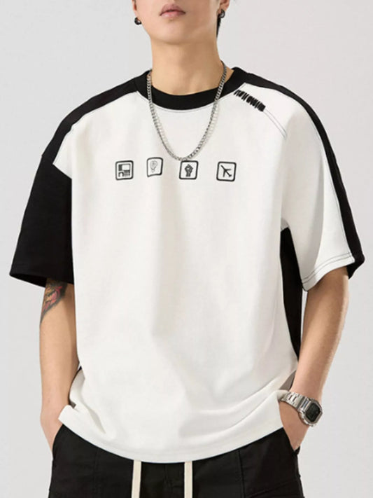 A man wearing a white short-sleeve casual t-shirt with black contrast stitching and sleeves.