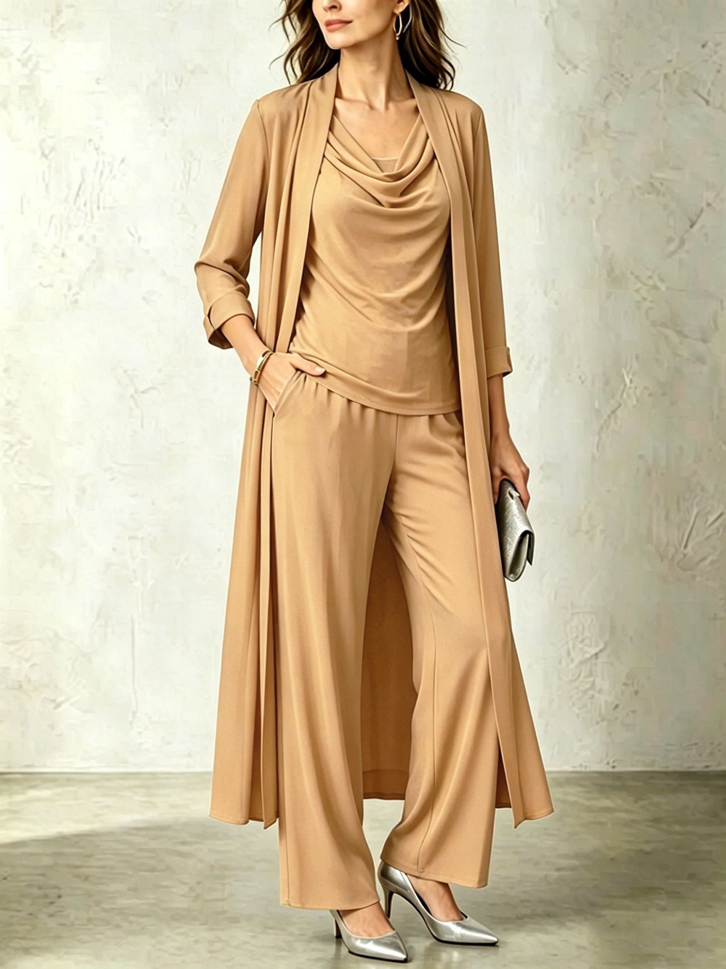 Camel tan three-piece women's set featuring a long open duster cardigan, sleeveless cowl neck top, and fluid wide-leg pants.