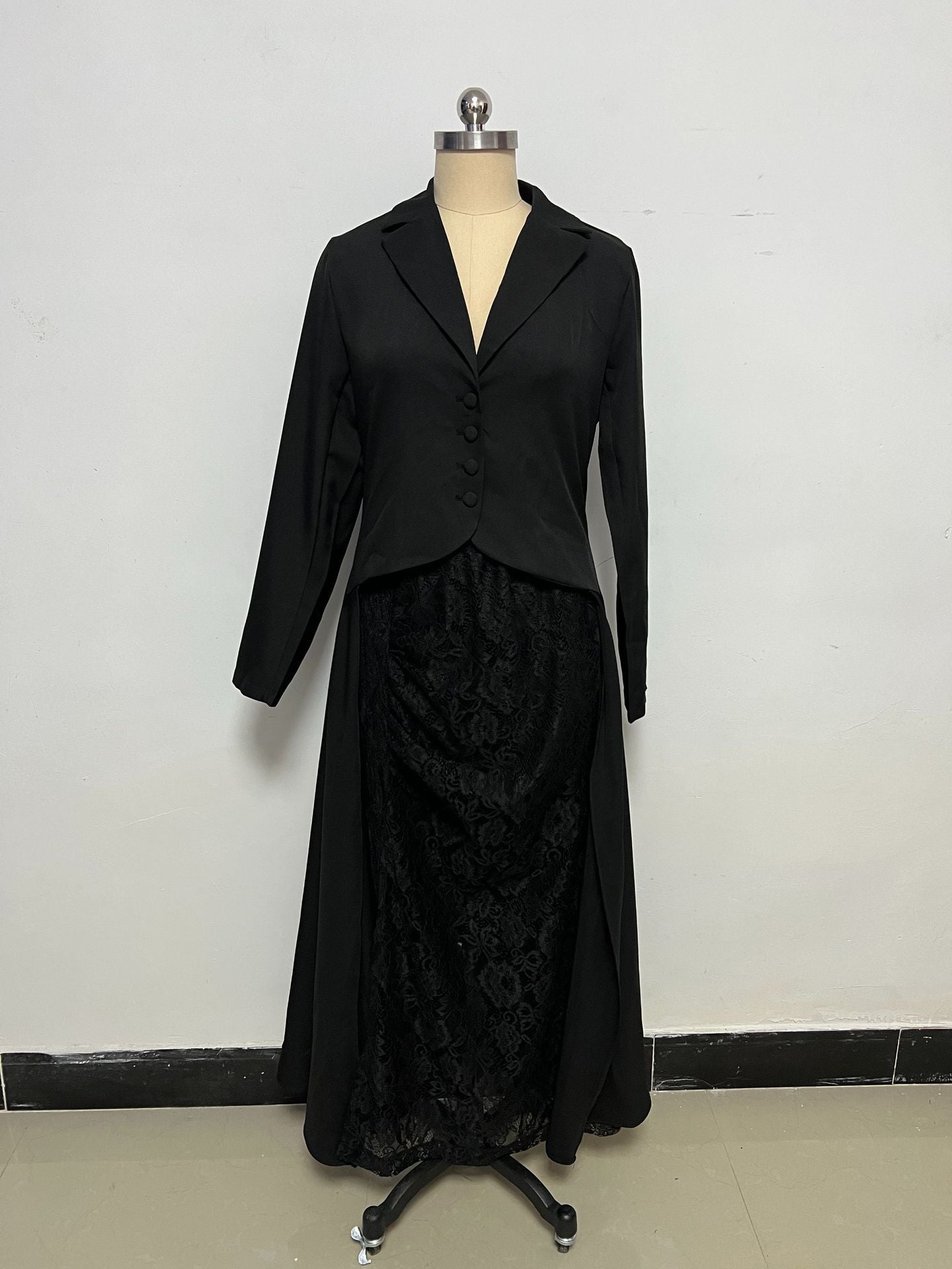 Women's black formal set displayed on a mannequin, featuring a long-sleeve V-neck blazer top and a long skirt with a floral lace overlay.