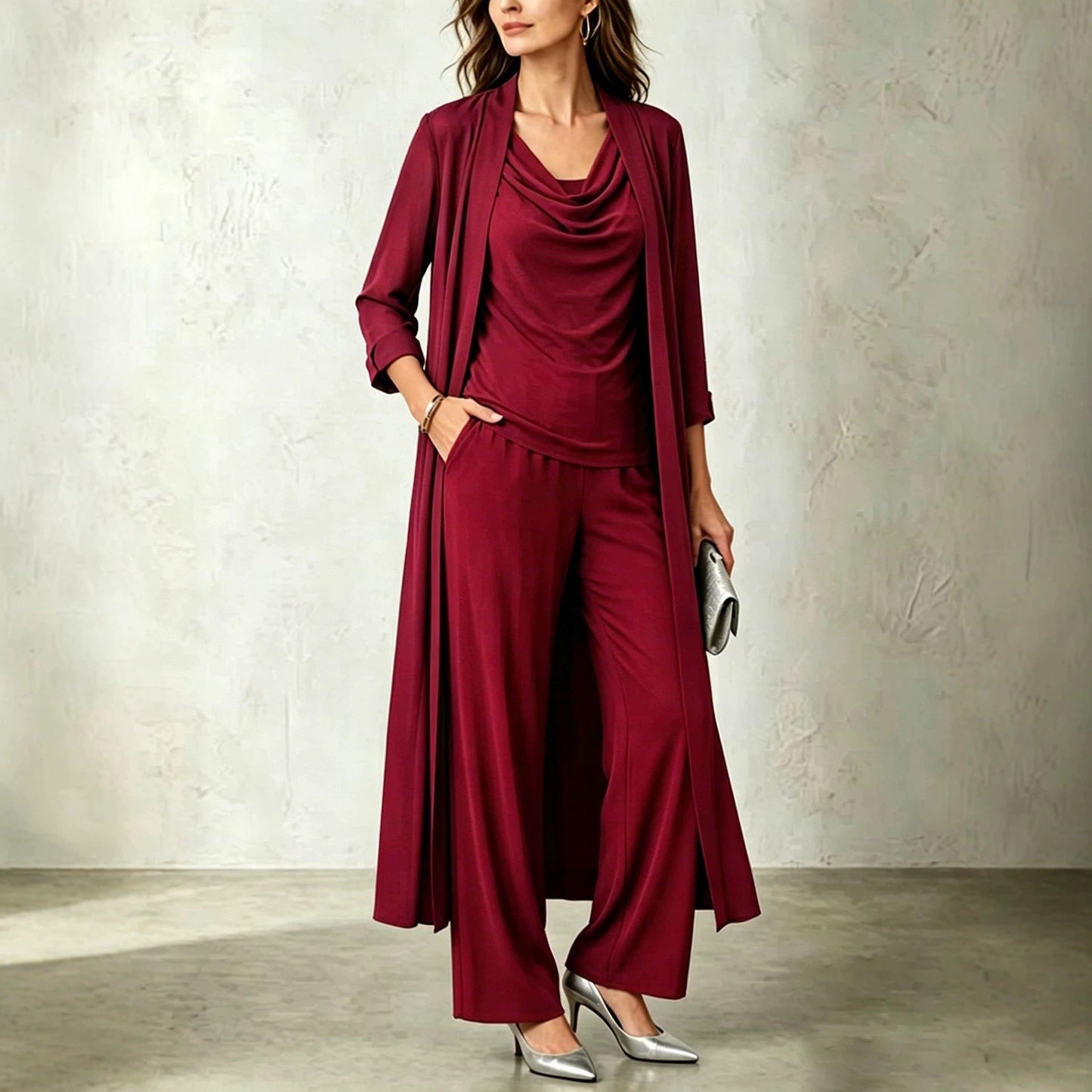 Wine red three-piece women's outfit featuring a floor-length open cardigan, matching cowl neck top, and wide-leg trousers.