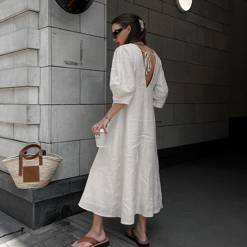 Front view of a light blue floral off-the-shoulder midi dress featuring a fitted silhouette, draped neckline, and flared asymmetric trumpet hem.