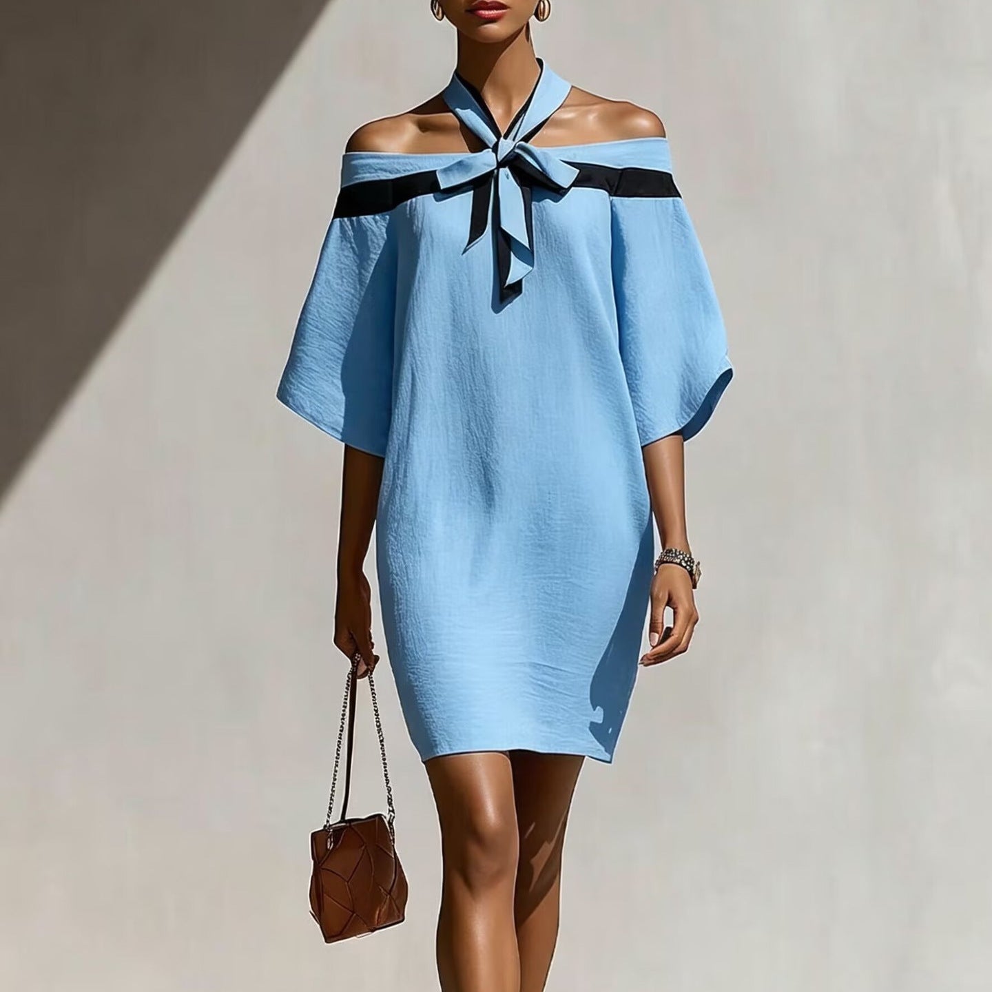Woman in light blue off-the-shoulder A-line mini dress with black bow collar detail and 3/4 wide sleeves
