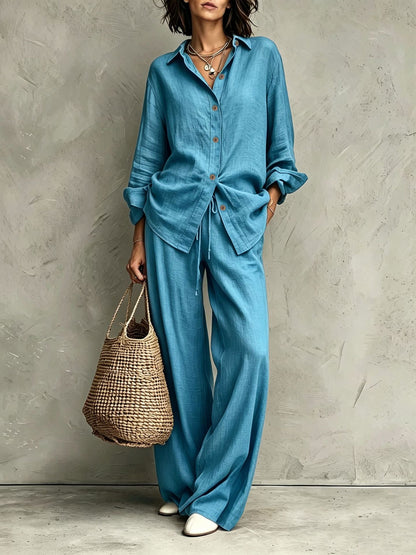Women's button-down shirt and wide-leg pants set in lake blue – full outfit front view showing relaxed casual silhouette and straw bag