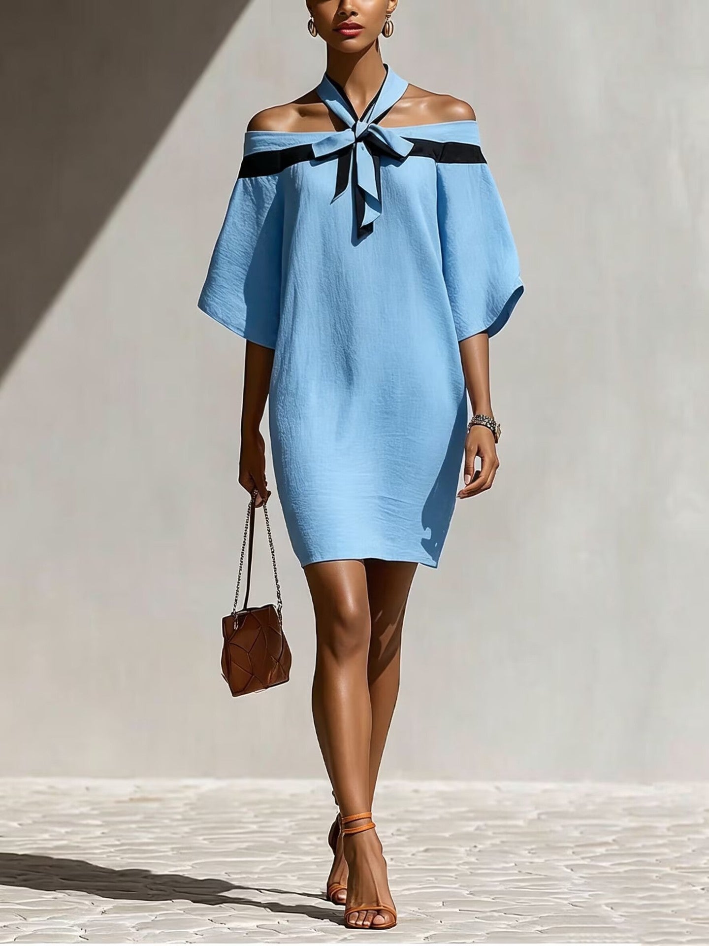 Woman in light blue off-the-shoulder A-line mini dress with black bow collar detail and 3/4 wide sleeves