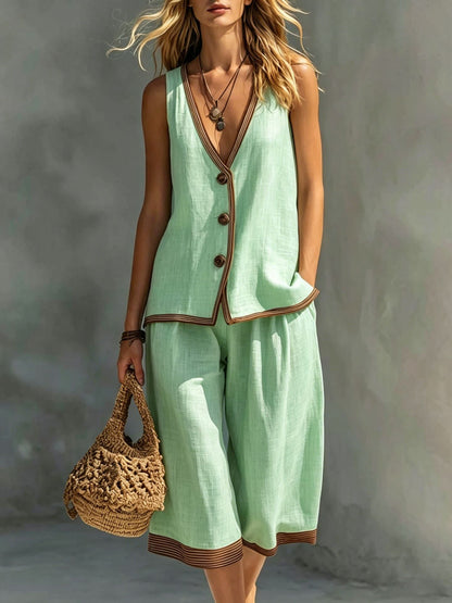 Women's light green sleeveless buttoned vest and matching cropped wide-leg pants two-piece set featuring contrast trim detailing, modeled outdoors with a woven handbag.