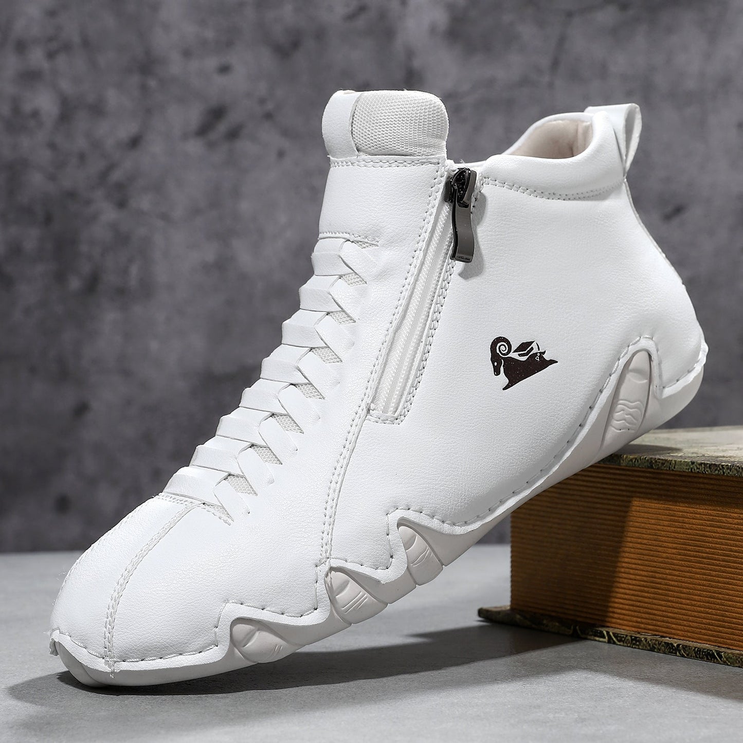 White suede high-top sneaker with front lace-up closure, side zipper, and unique rubber sole detail.