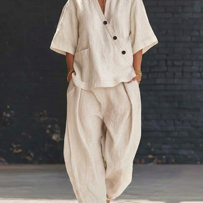Model wearing a beige V-neck short-sleeve top and matching high-waist trousers set.