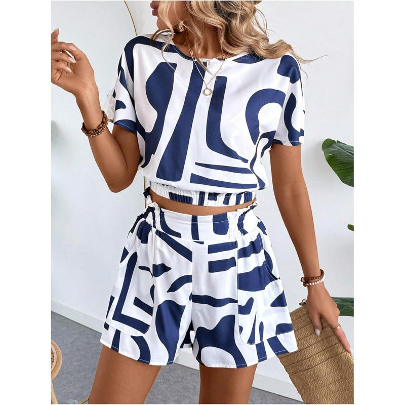 Woman wearing a printed casual two piece set featuring a blue and white geometric short sleeve top and matching high-waisted shorts.