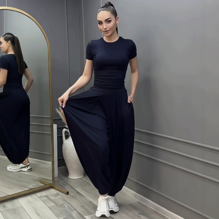 Women's dark navy blue two-piece set featuring a fitted short-sleeve crew neck tee and high-waisted wide-leg harem pants with cinched ankles.
