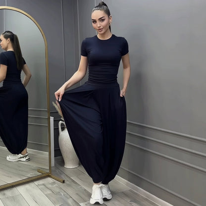 Women's dark navy blue two-piece set featuring a fitted short-sleeve crew neck tee and high-waisted wide-leg harem pants with cinched ankles.