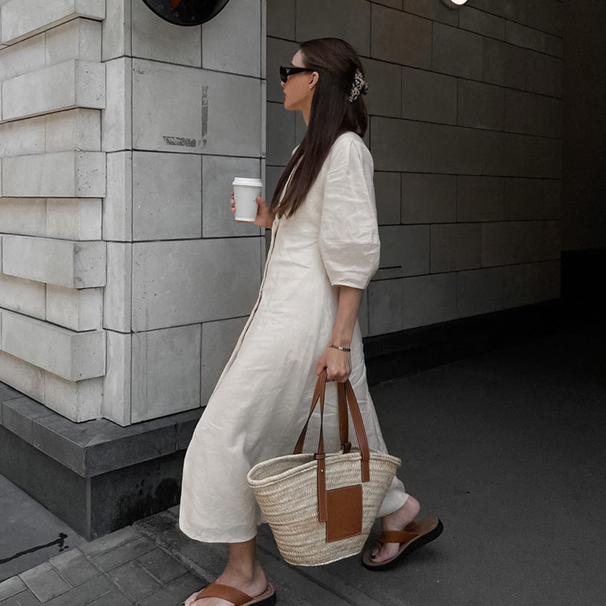 Detailed view of a light blue floral off-the-shoulder midi dress with a fitted waist and flared hem, paired with white ankle-strap heels and a matching mini handbag.