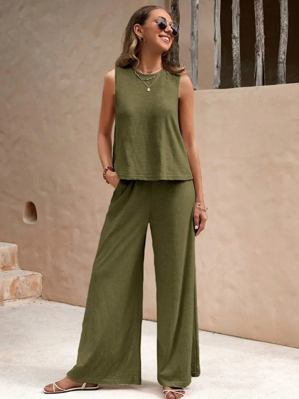 Front view of model wearing an army green sleeveless round neck top and high-waisted wide leg pants set with sunglasses
