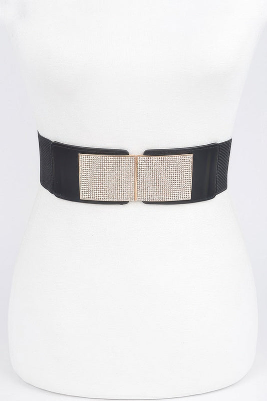 Front view of a wide black elastic stretch belt with a shimmering rhinestone-embellished metal buckle, styled on a white dress mannequin against a light background.