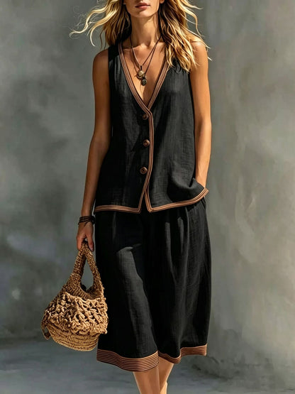 Women's black sleeveless buttoned vest and matching cropped wide-leg pants two-piece set featuring contrast trim detailing, modeled outdoors with a woven handbag.