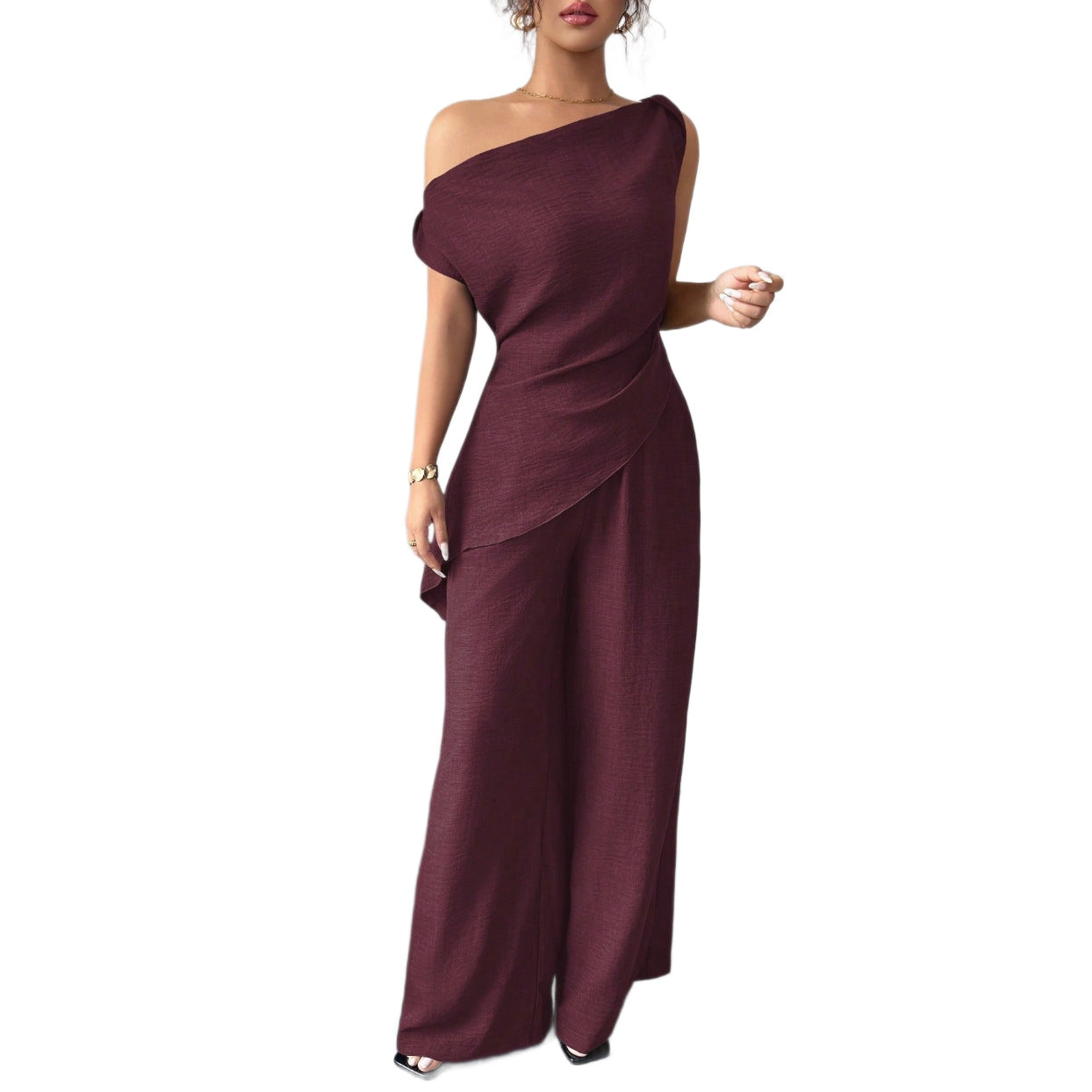 Woman wearing a dark plum casual two piece set featuring an asymmetric draped one-shoulder top and matching high-waisted wide-leg pants.
