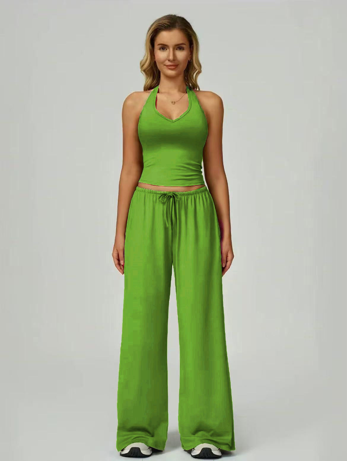 Women's sporty crop tank and wide-leg pants set in green, full outfit front view showing V-neck crop top and wide-leg silhouette