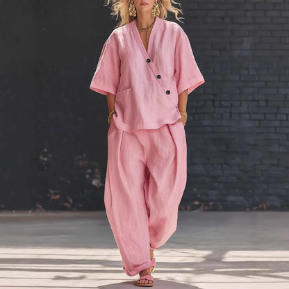 Woman wearing a loose pink V-neck short-sleeve top and high-waist relaxed-fit trousers two-piece set.