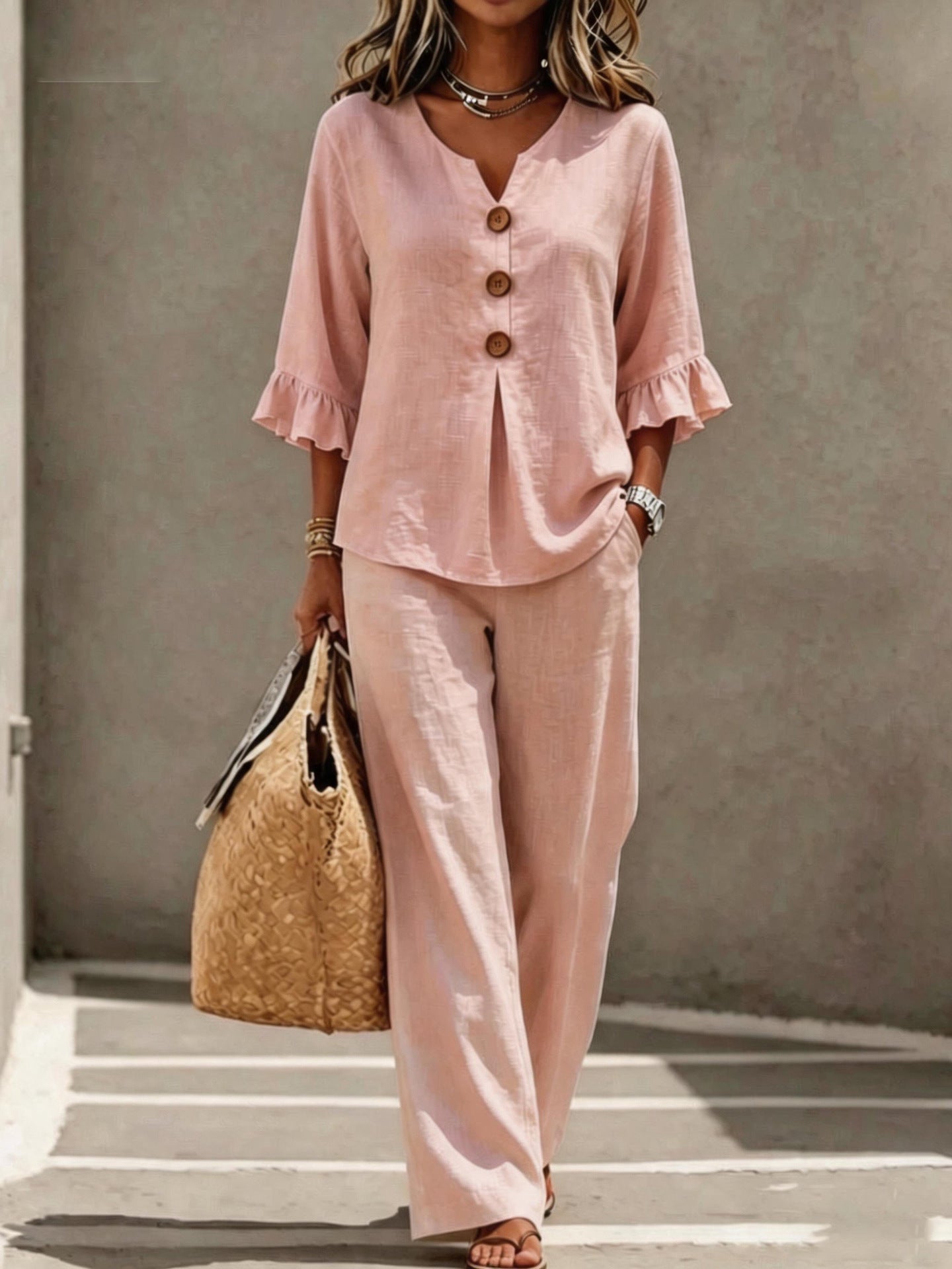 Women's two-piece set in pink, featuring a button-down V-neck ruffle top, matching relaxed-fit pants, and three-quarter sleeves.