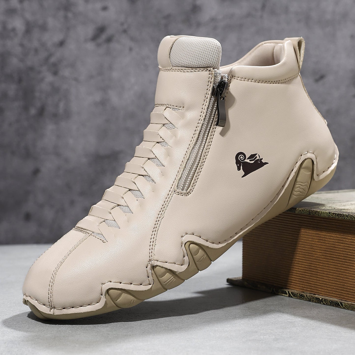 Cream suede high-top flat casual shoe with front lace-up closure, side zipper, and wavy rubber sole detail.