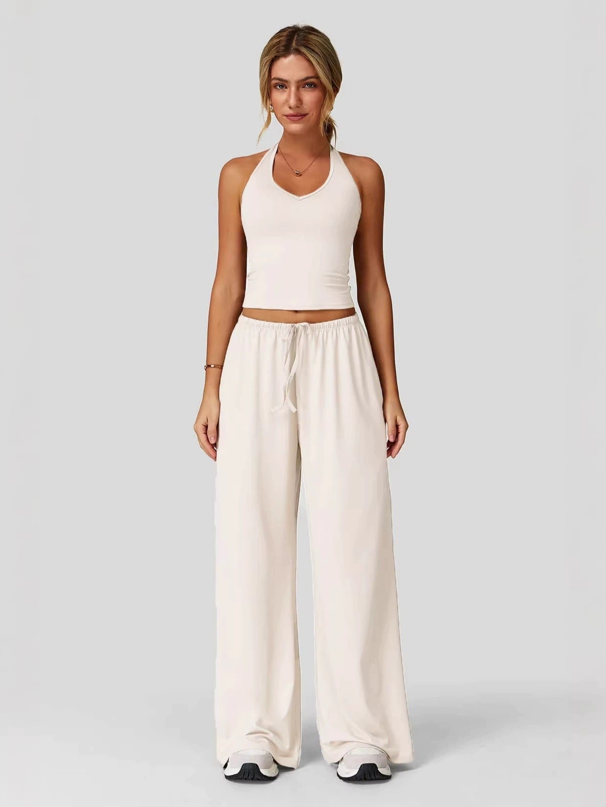 Women's sporty crop tank and wide-leg pants set in white, full outfit front view showing V-neck crop top and wide-leg silhouette